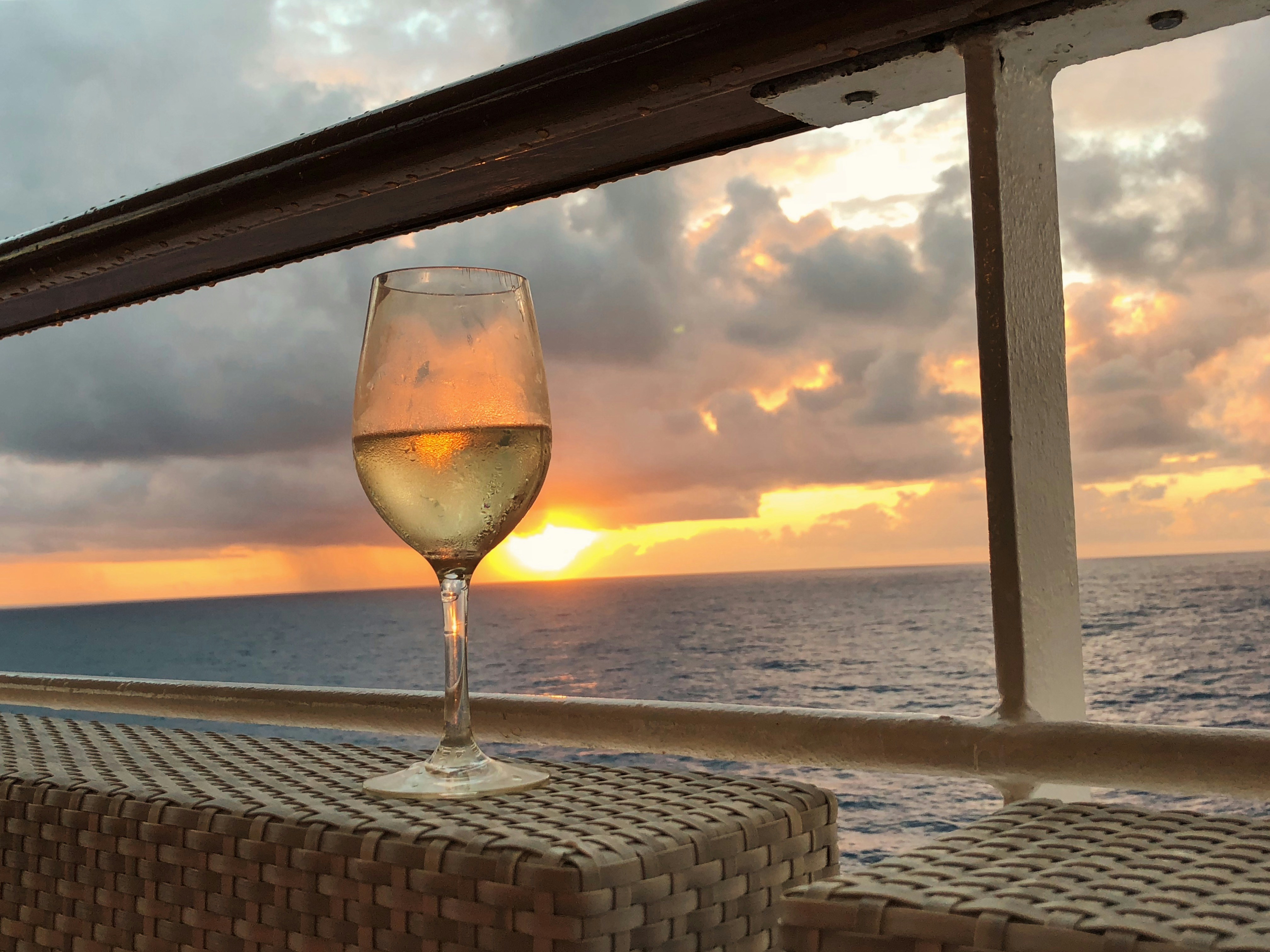 Wine glass at sunset on a cruise deck
